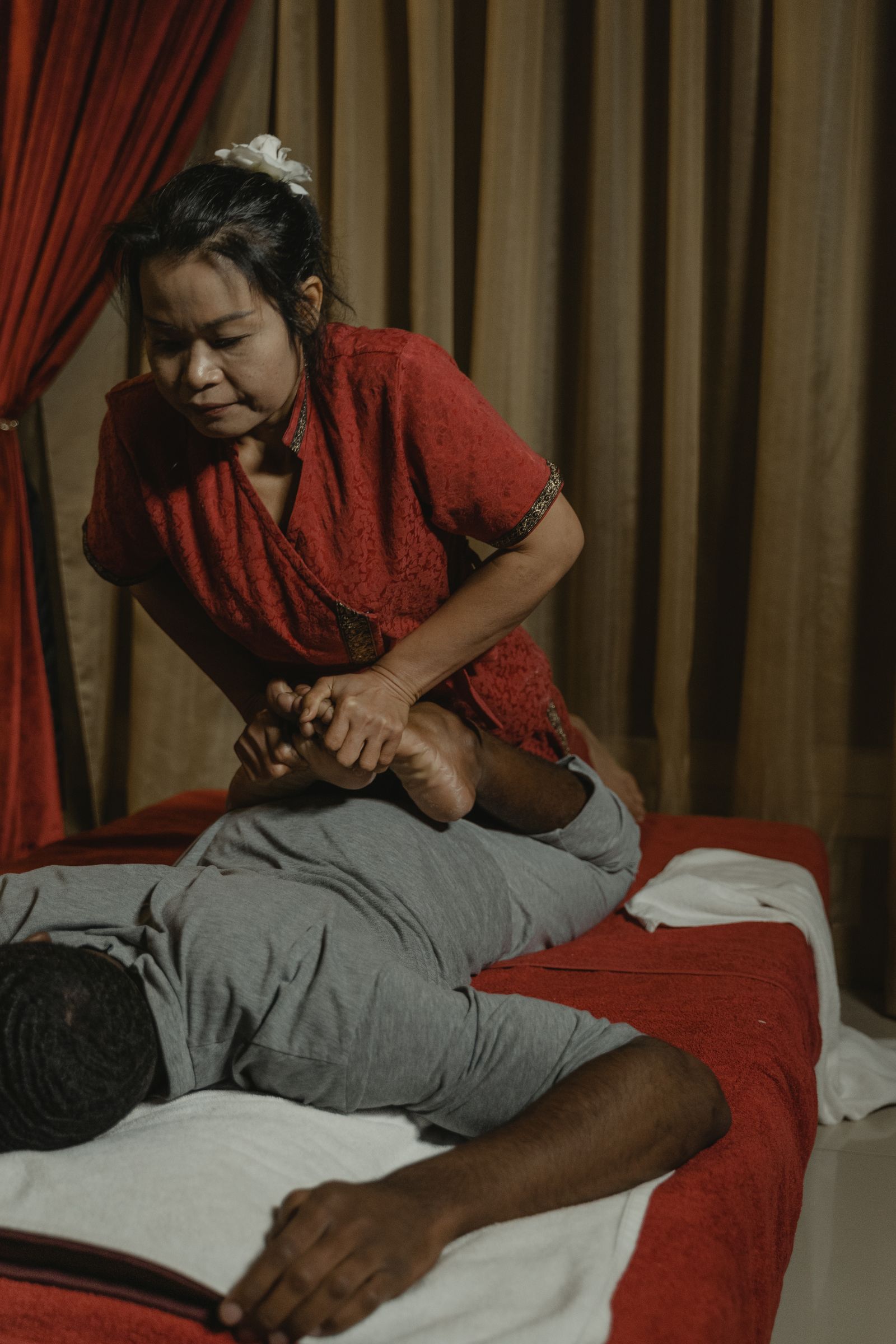 Therapeutin führt eine traditionelle Thai-Massage im Liegen durch